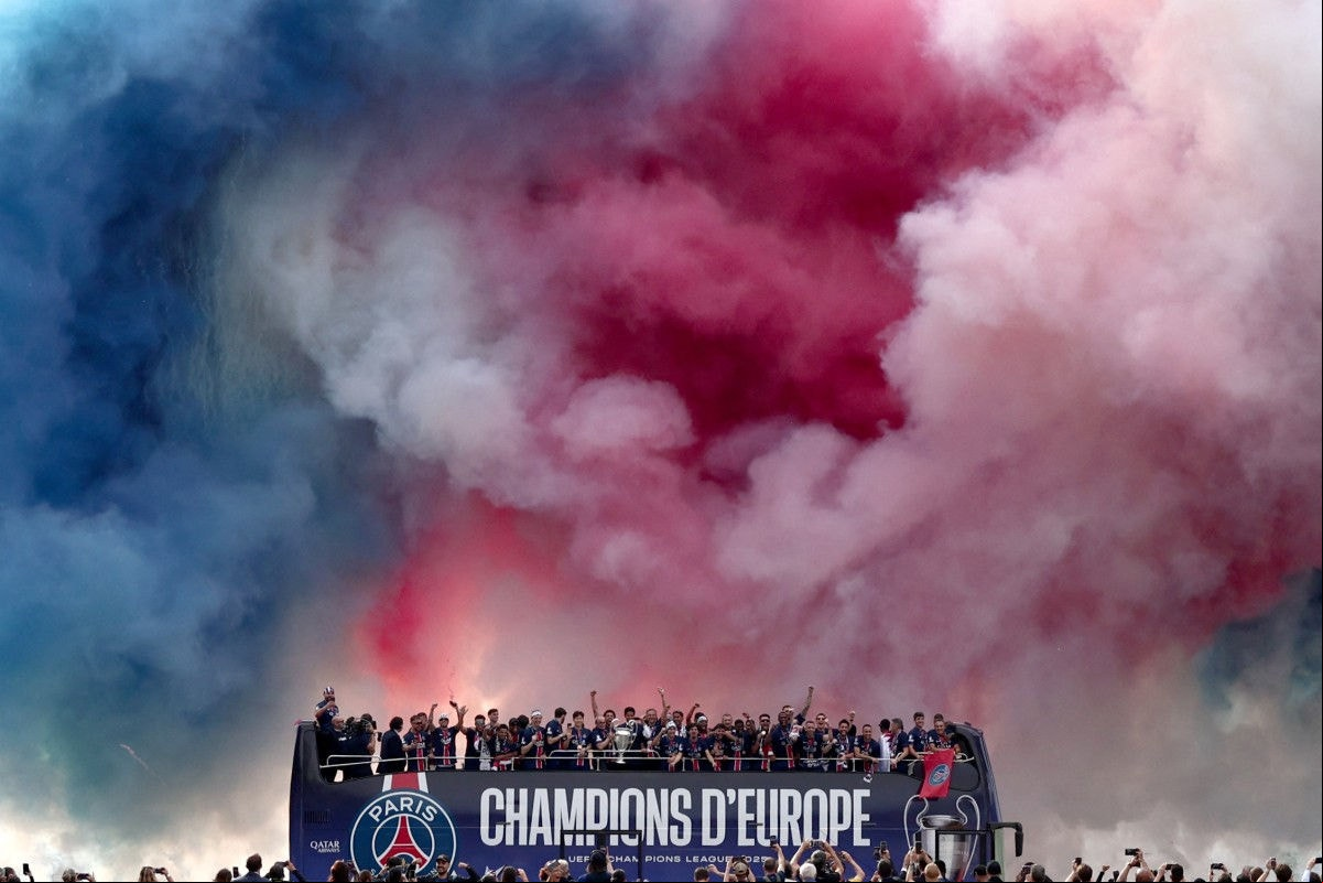 Paris Saint-Germain's players light smoke flares as they parade on a bus on the Champs-Elysees avenue in Paris on June 1, 2025, a day after PSG won the 2025 UEFA Champions League final football match against Inter Milan in Munich. (Photo by Thibaud MORITZ / AFP)